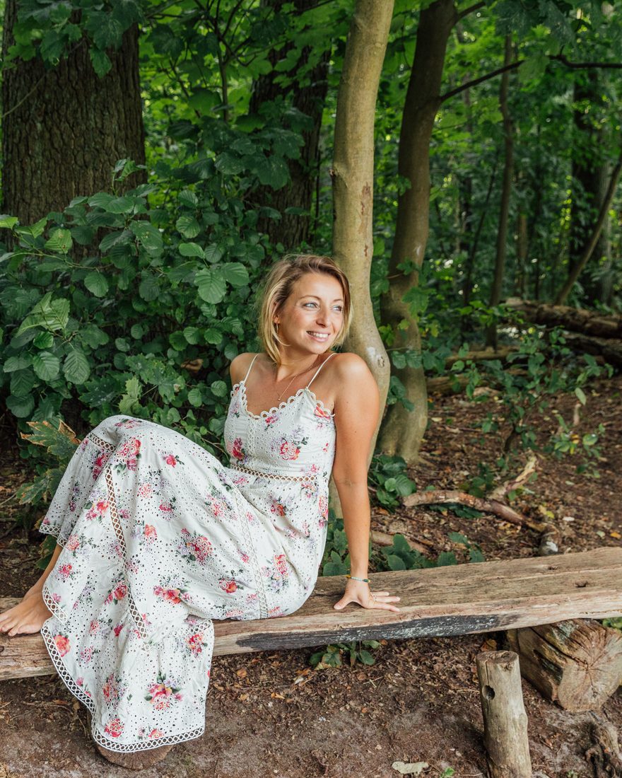 Anja Staufenbiel auf einer Holzbank im Wald